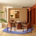 THAT Z SHOW apartment by Atelierzero, Milan, dining area with round dark red table and blue scalloped rug