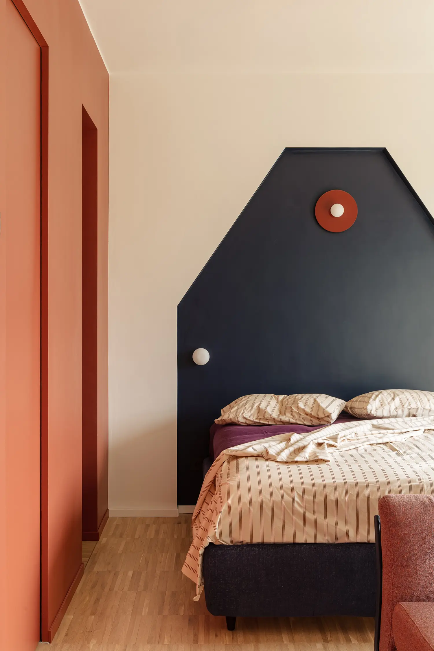 THAT Z SHOW apartment Milan, Atelierzero, bedroom with angled navy headboard and Michael Anastassiades sconce