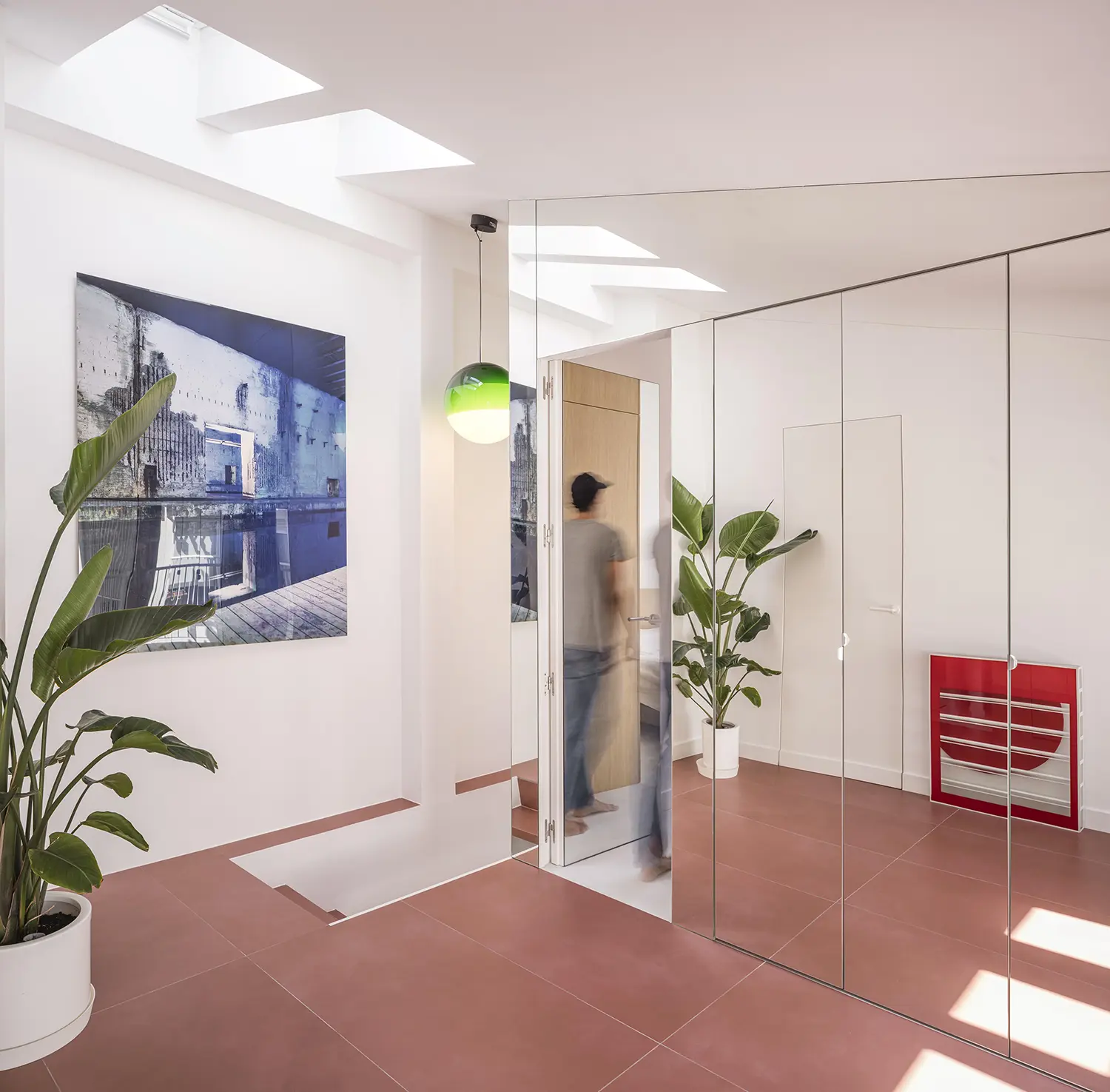 Attic corridor with round porthole window on door, child visible through open bathroom door