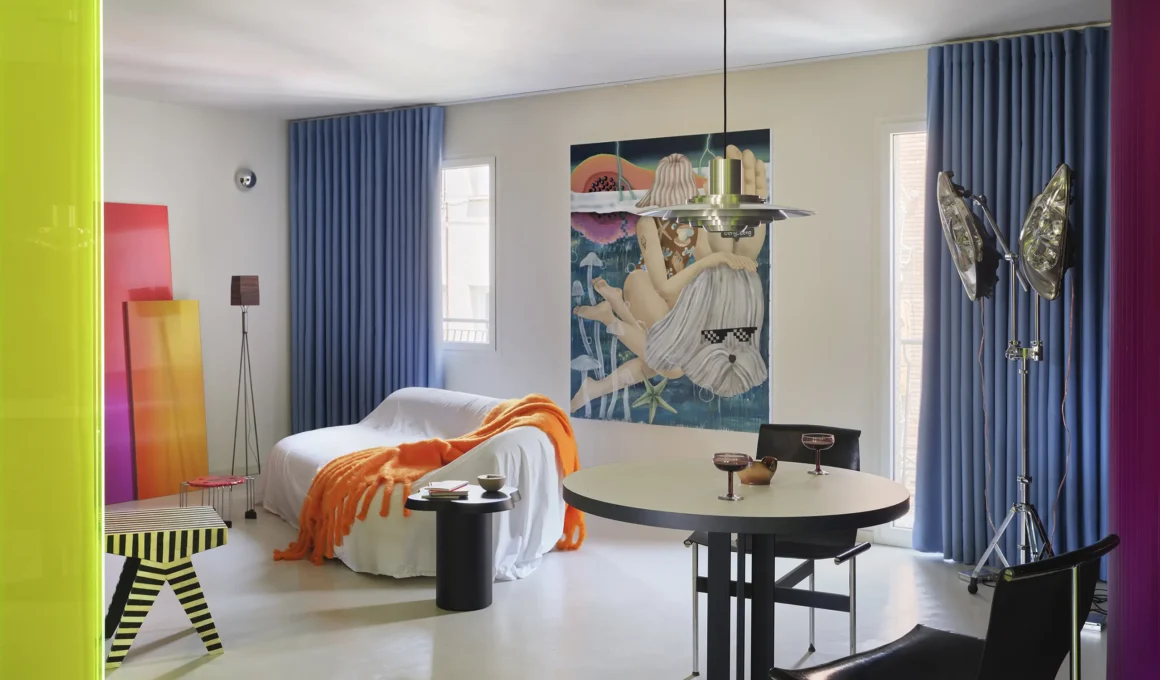 Macedonia apartment by Bardo, Madrid — living and dining area with neon acrylic threshold, blue curtains, and vintage artwork
