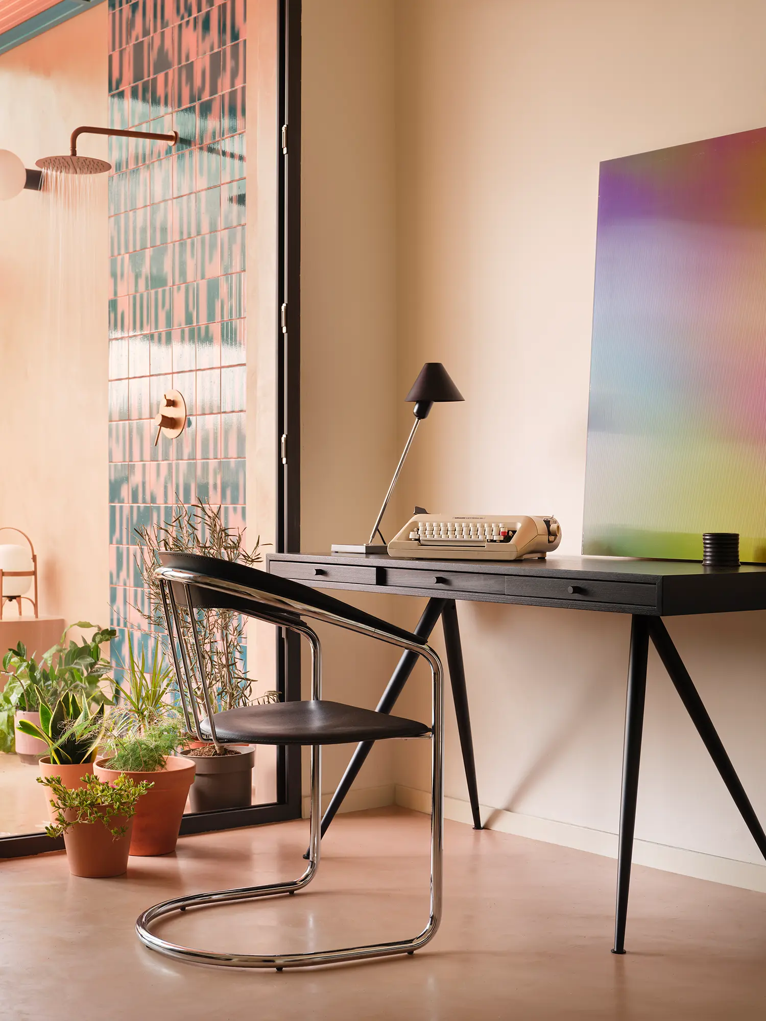 Macedonia by Bardo, workspace corner with black desk, vintage typewriter, and gradient painting near patterned tile bathroom