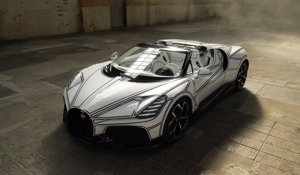 Bugatti W16 Mistral 'Blanc Éternel' roadster, front three-quarter elevated view, white bodywork with black line graphic, industrial warehouse interior