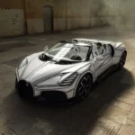 Bugatti W16 Mistral 'Blanc Éternel' roadster, front three-quarter elevated view, white bodywork with black line graphic, industrial warehouse interior