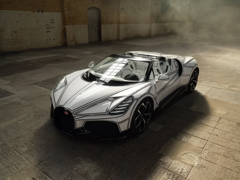 Bugatti W16 Mistral 'Blanc Éternel' roadster, front three-quarter elevated view, white bodywork with black line graphic, industrial warehouse interior