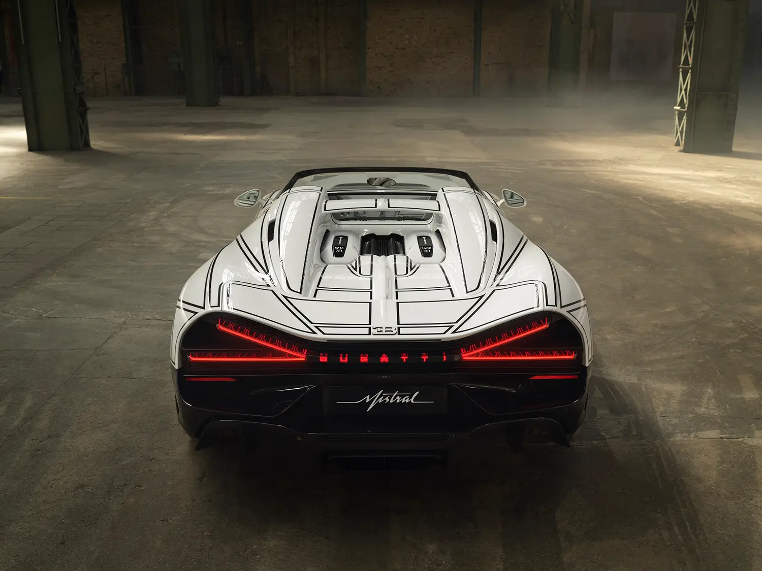 Bugatti W16 Mistral 'Blanc Éternel', rear straight-on view, illuminated red X-shaped taillights, black line graphic across engine cover