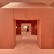CARTIER exhibition at NGV Melbourne, designed by Studio Sabine Marcelis and CLOUD: salmon-pink volumetric passage with chamfered corners connecting gallery zones