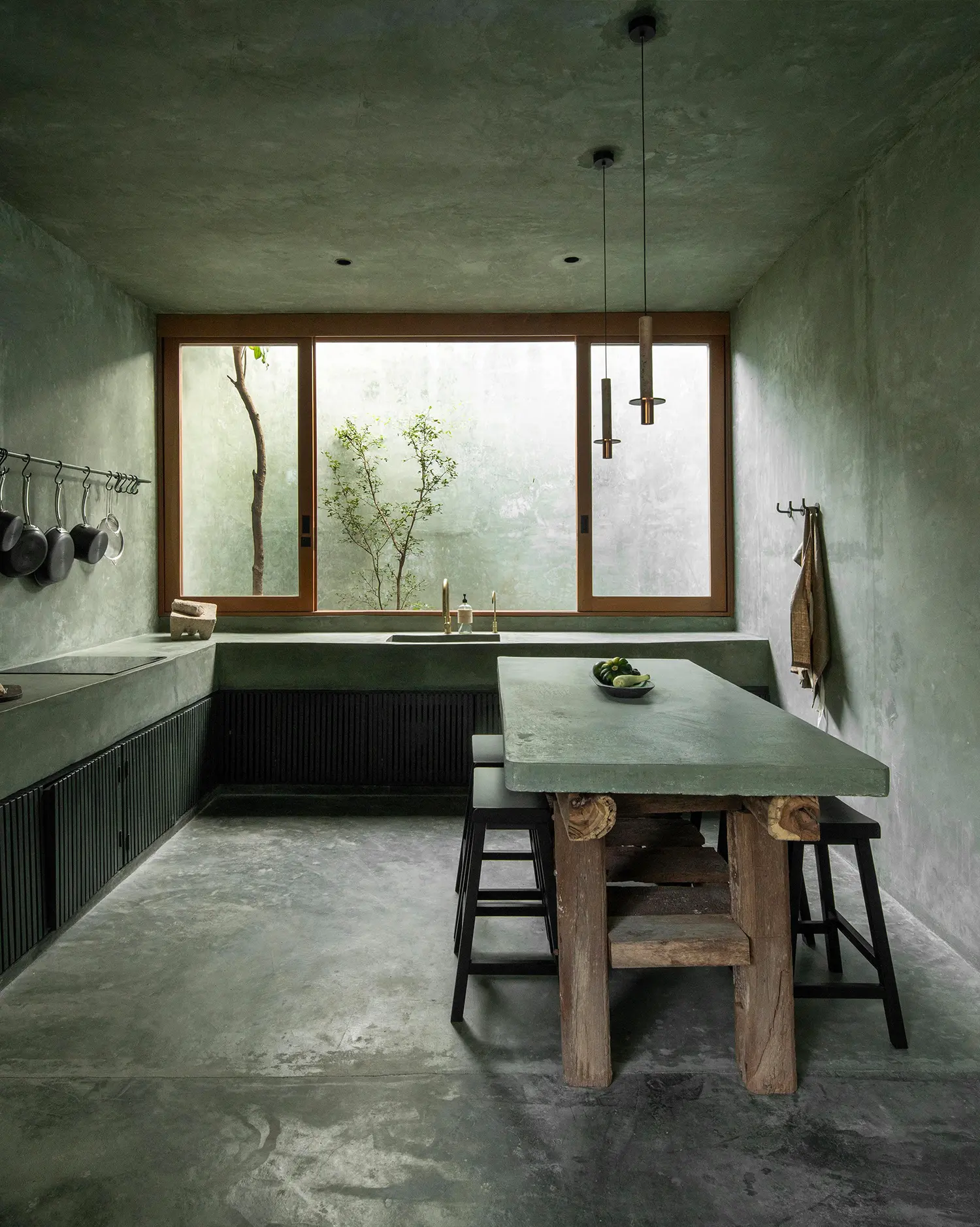 Casa Gruta concrete kitchen with reclaimed wood island and brass pendant lighting, Salvador Román & Adela Mortera