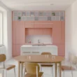 Casa Tahiti by Margine, pink kitchen and dining area, white Krion island, oak table, Arabescato terrazzo flooring