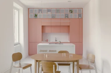 Casa Tahiti by Margine, pink kitchen and dining area, white Krion island, oak table, Arabescato terrazzo flooring