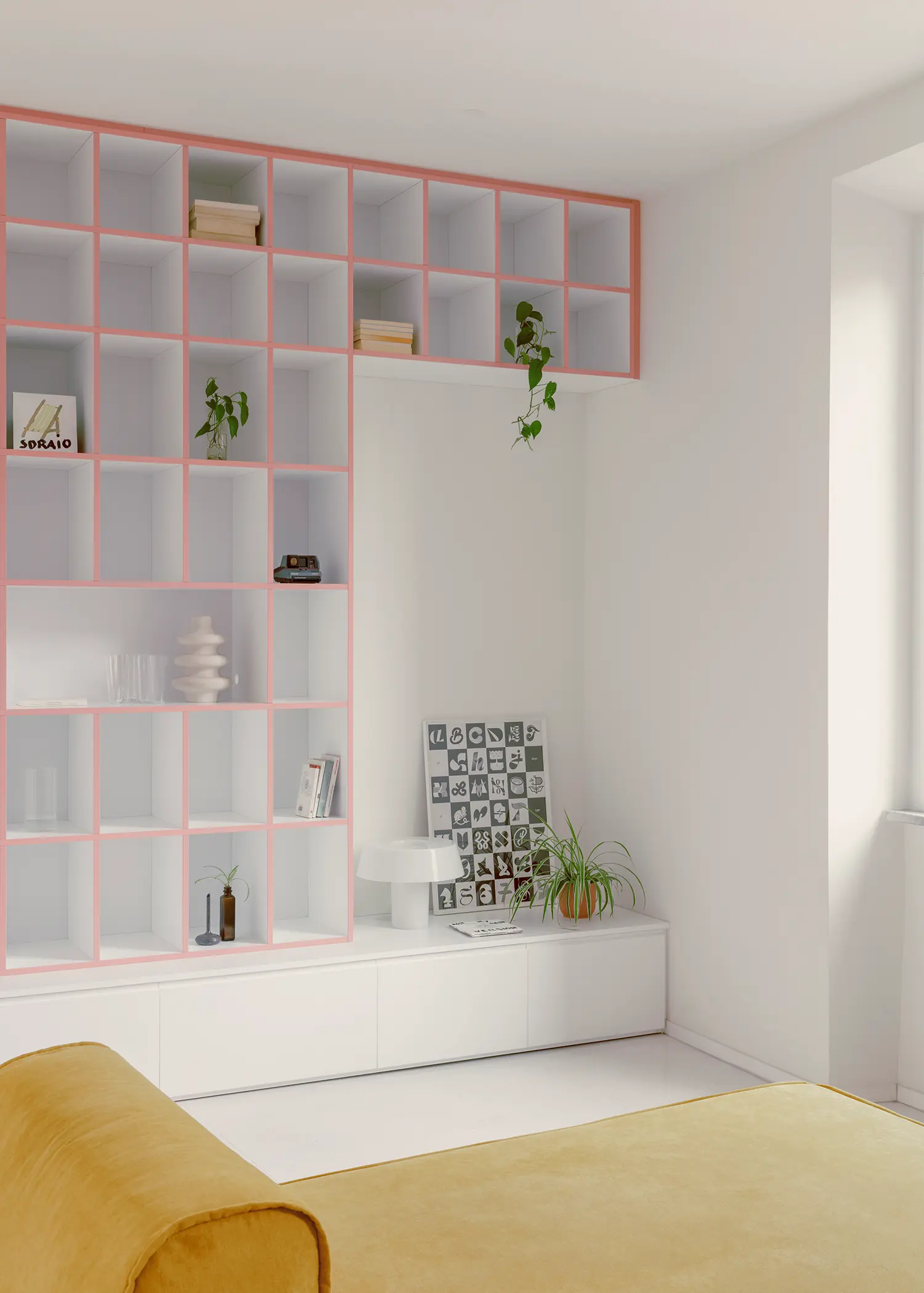 Casa Tahiti by Margine, custom bookcase corner, pink grid profiles, books and plants, yellow sofa edge