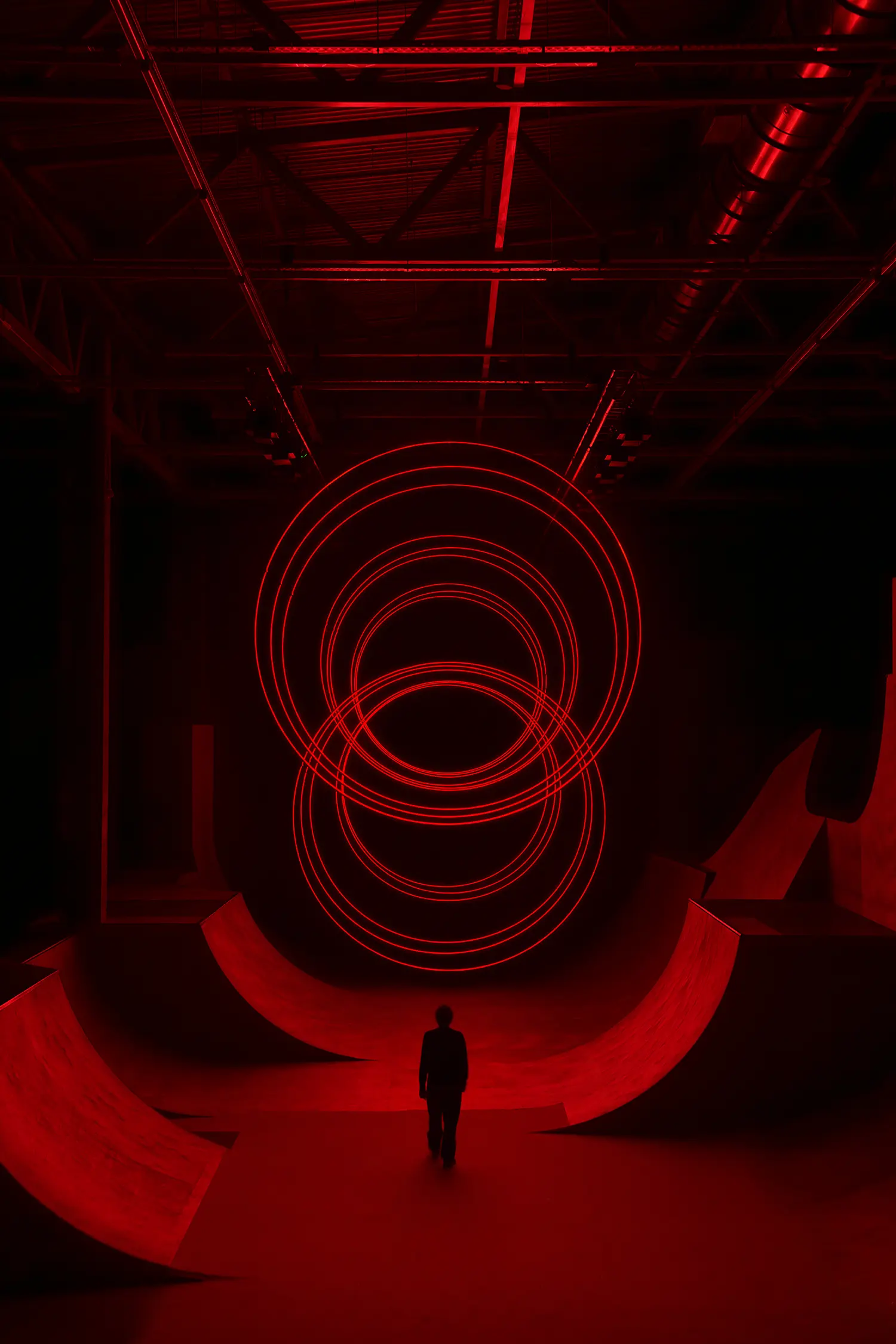 SpY's CYCLES N2 rings forming a tunnel-like oval above a figure standing between two curved ramps