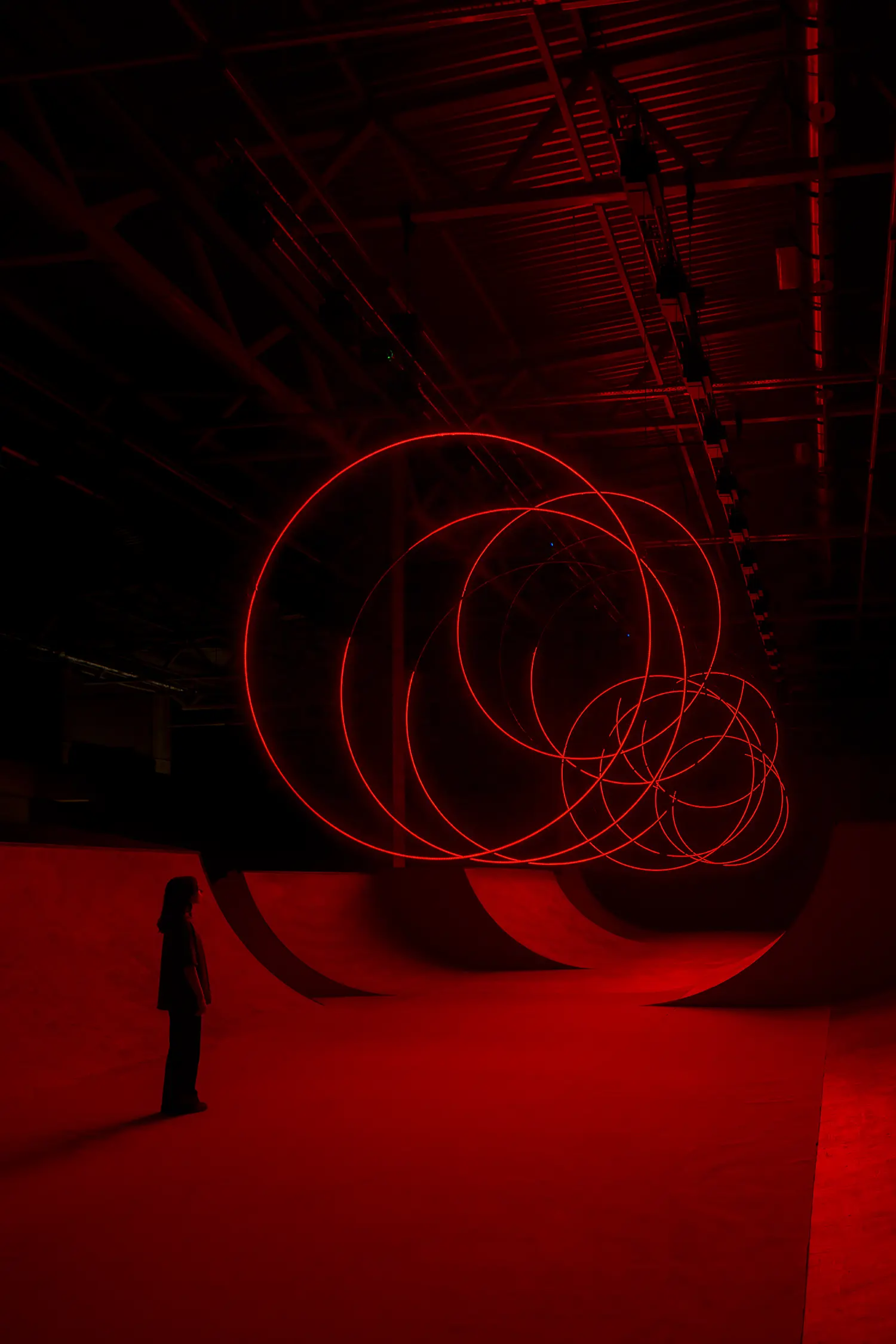 Detail view of SpY's CYCLES N2 rings overlapping diagonally above a viewer looking up inside the Kazan hall