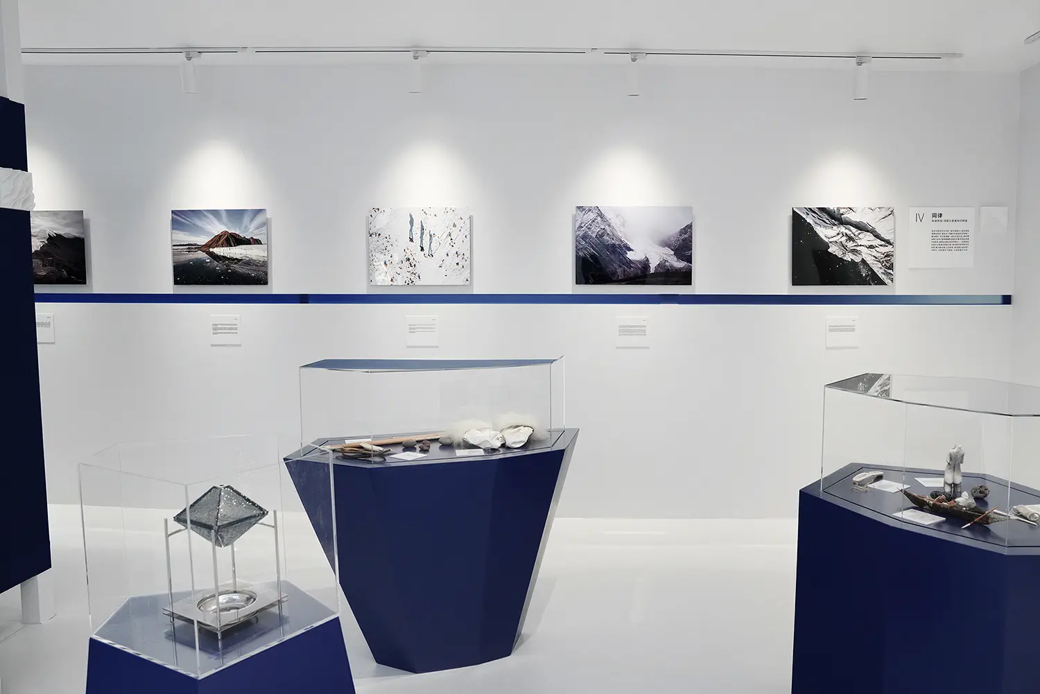 Resonance chapter of the Dayuan Design exhibition, glacier photographs above blue plinths holding polar artefacts and a liuli object