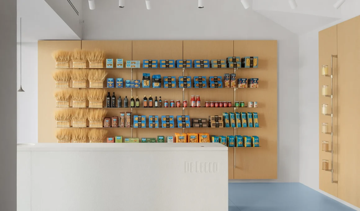 De Cecco Flagship Store by Studio Francesco Faccin, Pescara, wheat sheaf display wall, steel shelving, white stone counter with De Cecco engraving