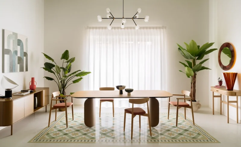 Elia's Home by In-Nova Studio dining area, sage green ceiling, oak table on curved base, geometric terrazzo carpet inlay, Aversa