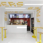 Interior of Fab Fries Freddy by Ninetynine, Amsterdam, showing white tile walls and ceiling narrowing toward a red-tiled prep counter