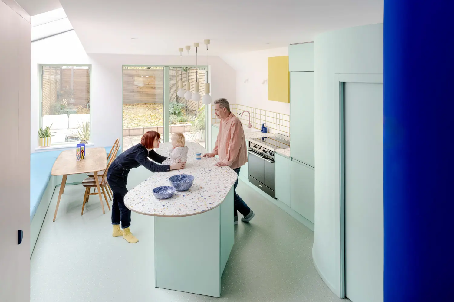 Beacon House kitchen island by Office S&M — family at terrazzo counter, glazed tile splashback