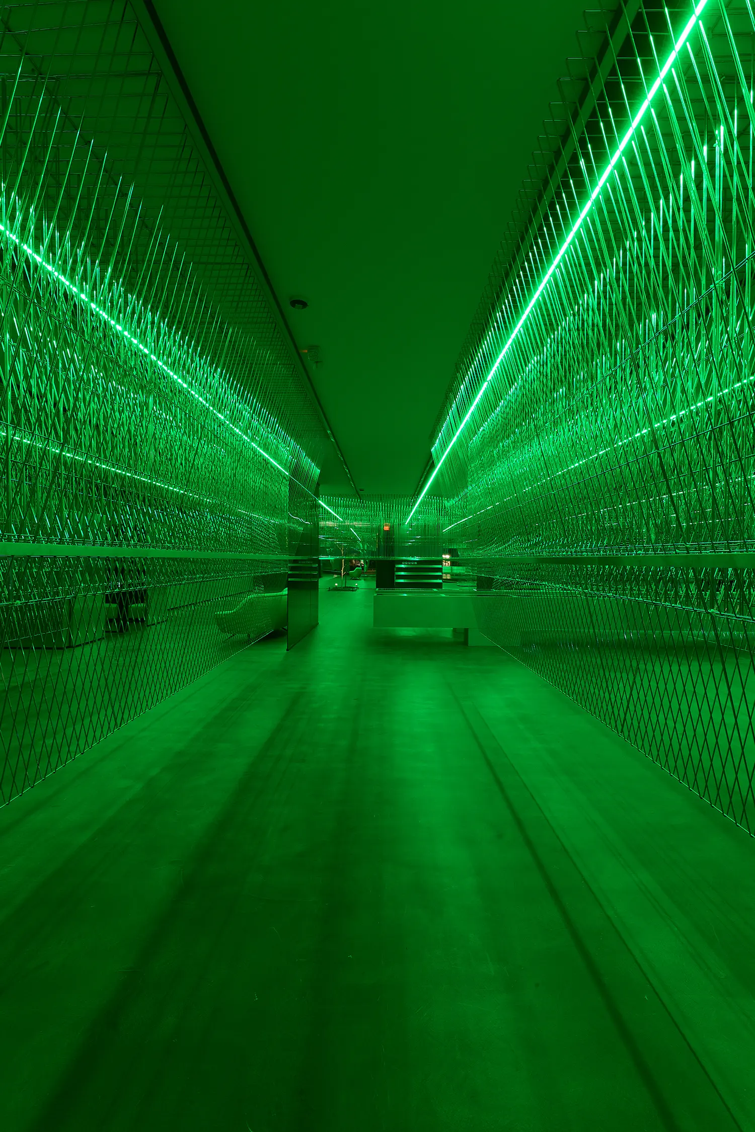 HLORENZO Los Angeles flagship by Oliviero Baldini, vertical corridor lined with perforated metal mesh under green lighting
