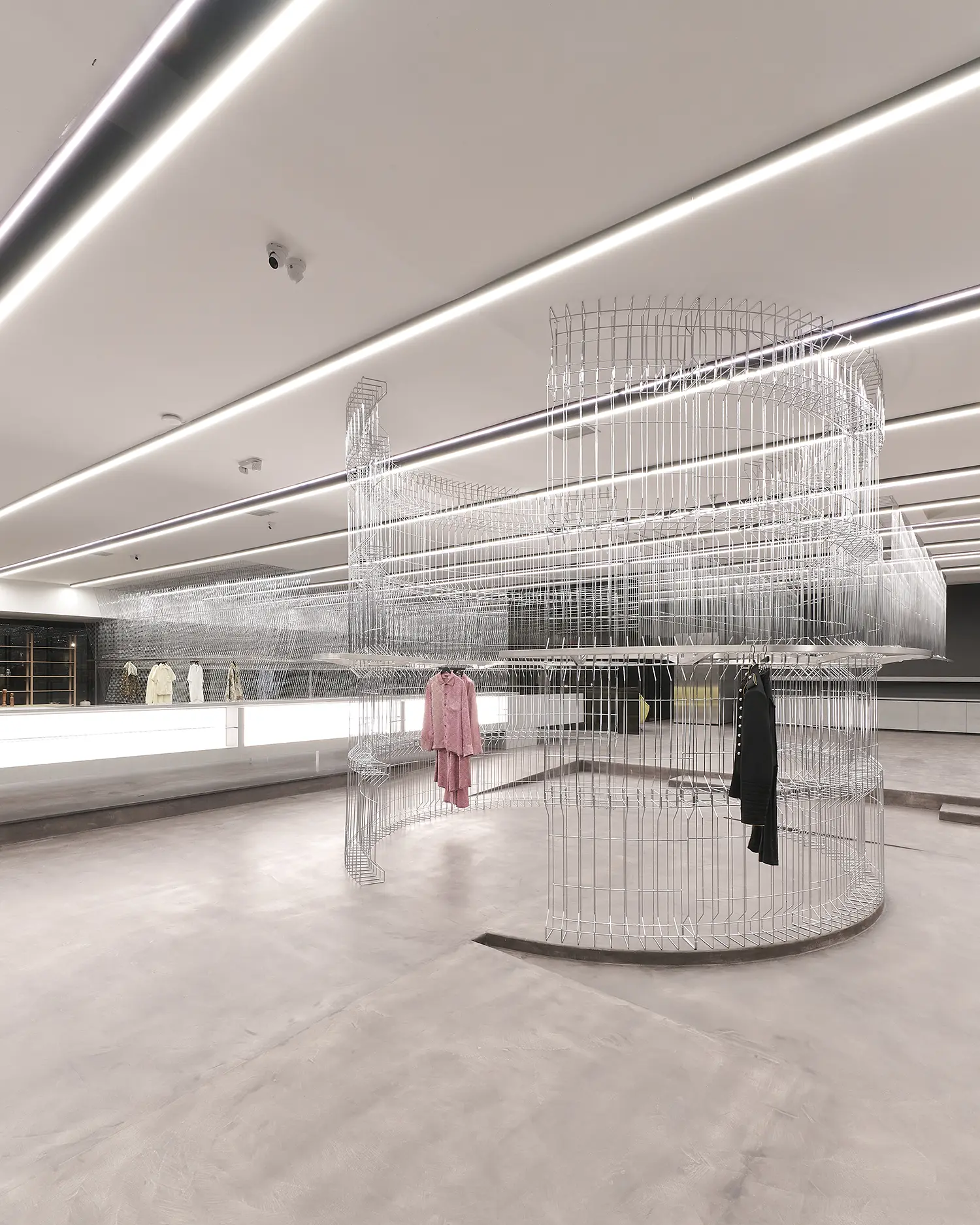 HLORENZO Los Angeles flagship by Oliviero Baldini, wire-frame suspended structure holding garments above open concrete floor