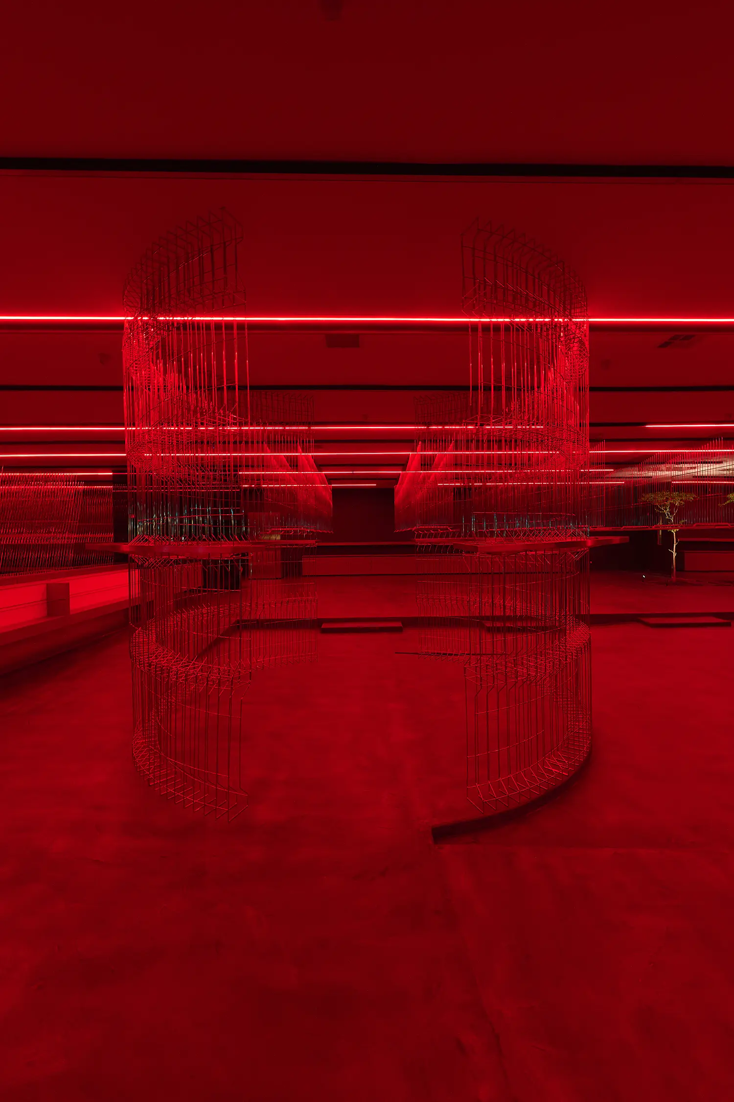 HLORENZO Los Angeles flagship by Oliviero Baldini, cylindrical wire-frame installations under red lighting with reflective concrete floor