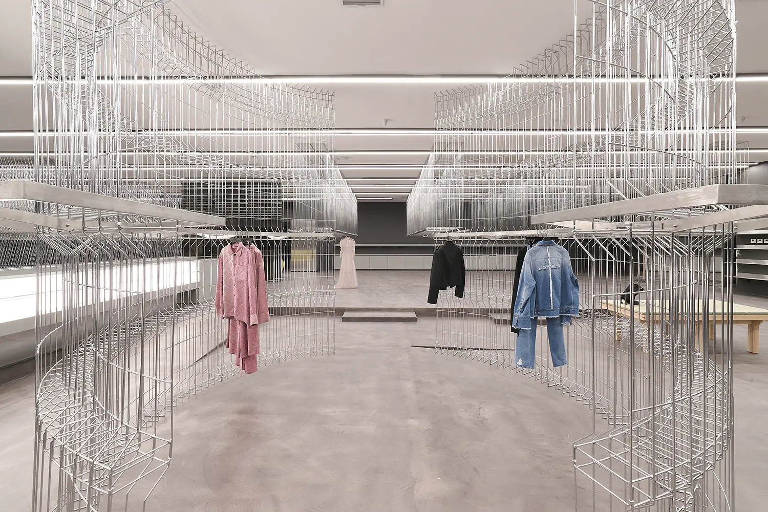 HLORENZO Los Angeles flagship by Oliviero Baldini, central aisle with wire-frame displays holding womenswear and menswear pieces