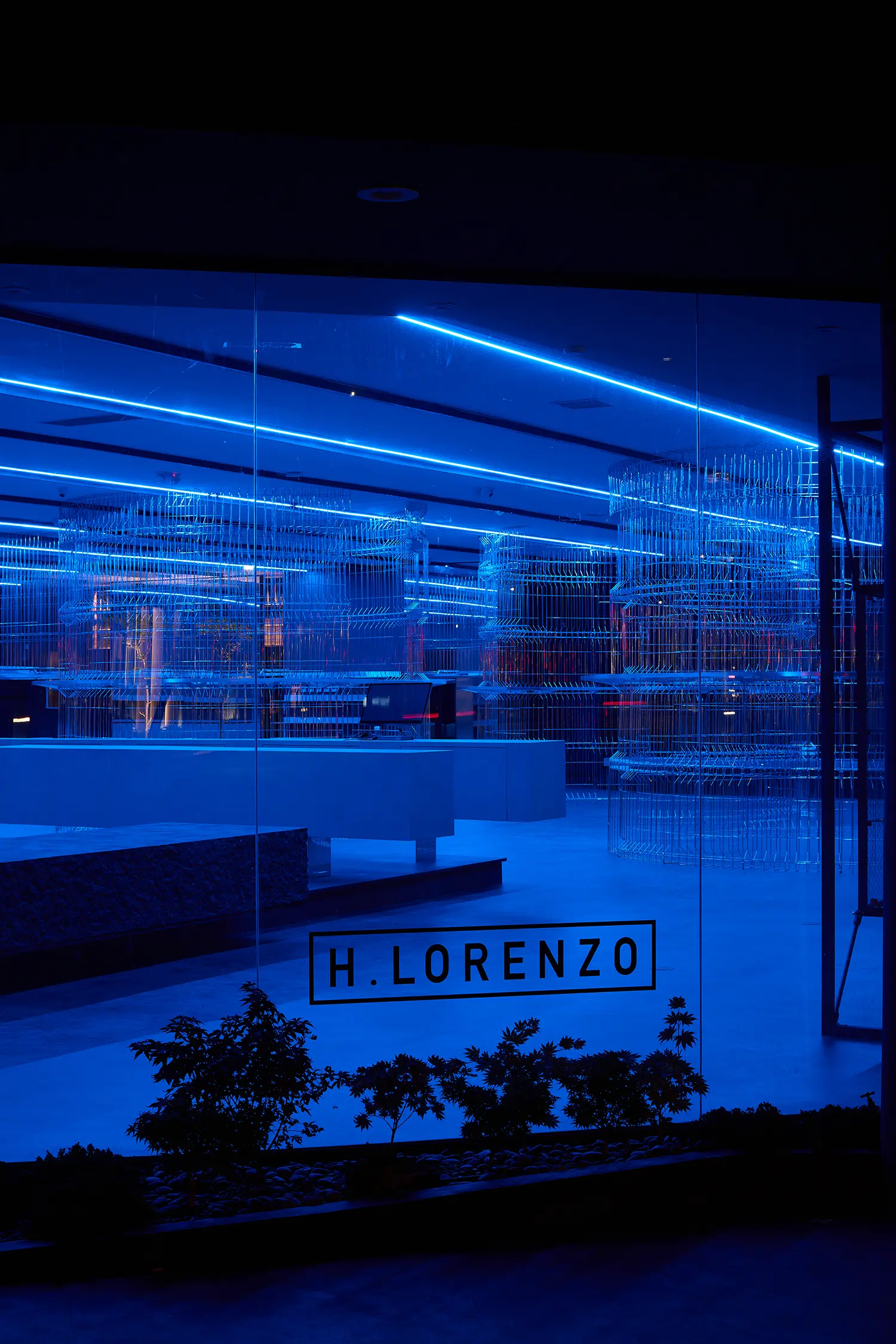 HLORENZO Los Angeles flagship by Oliviero Baldini, storefront window at night with illuminated interior visible from Beverly Boulevard