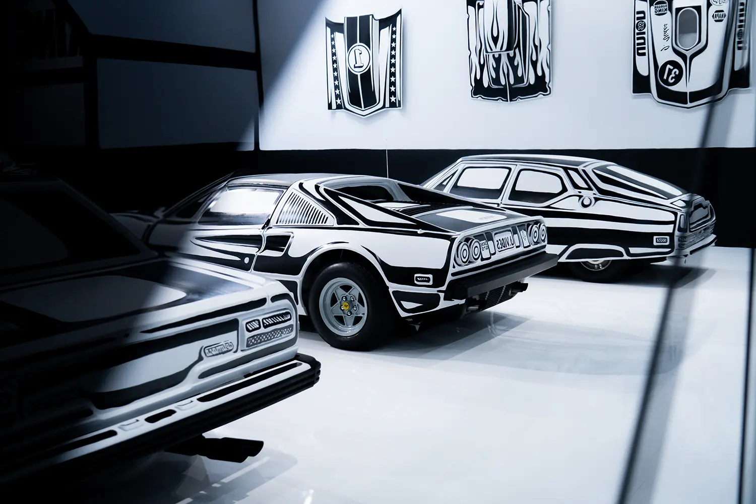 Two hand-painted vehicles at Joshua Vides Flat Out exhibition, black-and-white line work, Petersen Automotive Museum gallery