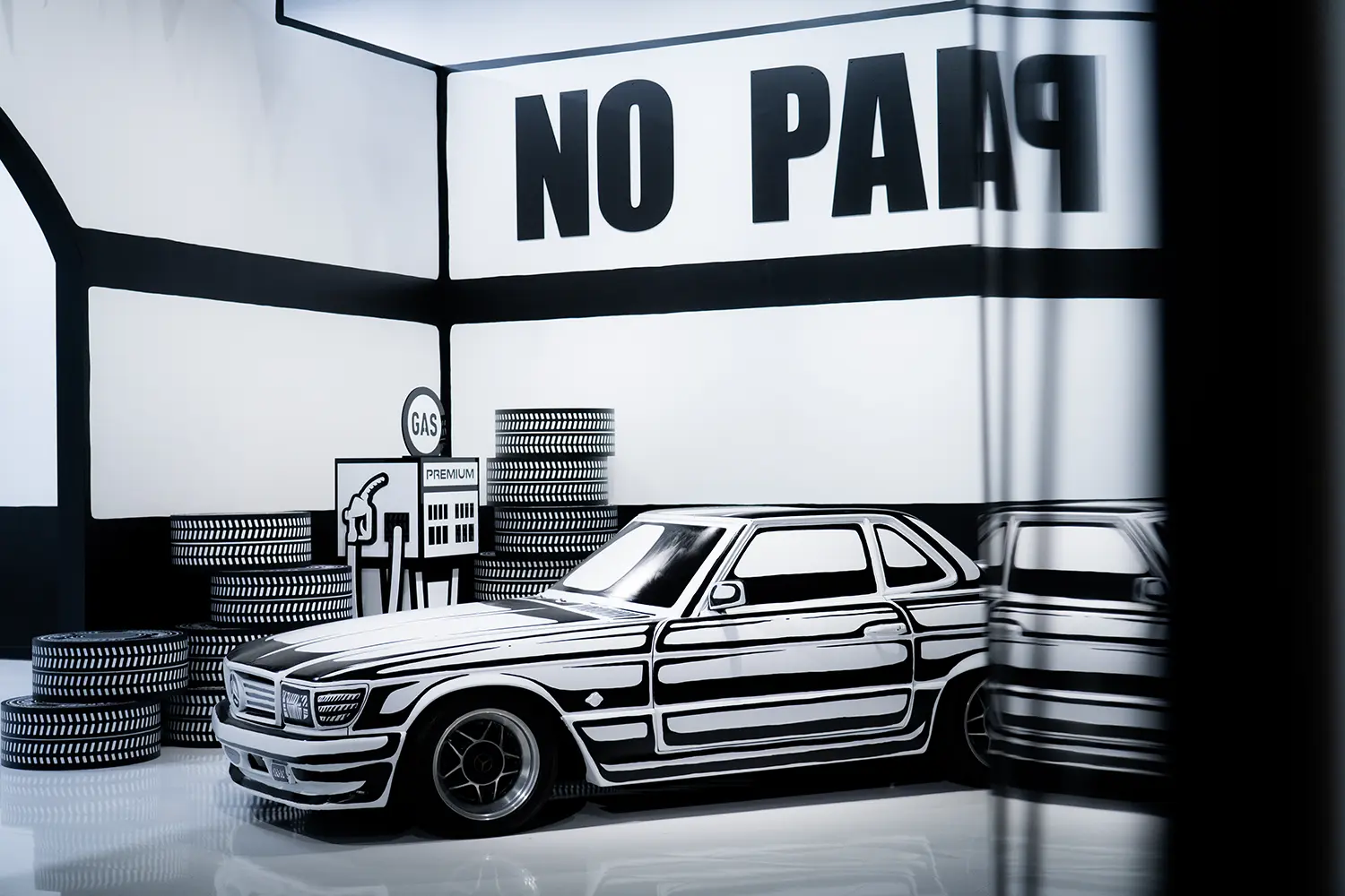 Hand-painted Mercedes-Benz coupe at Joshua Vides Flat Out exhibition, black-and-white livery, No Parking wall graphic