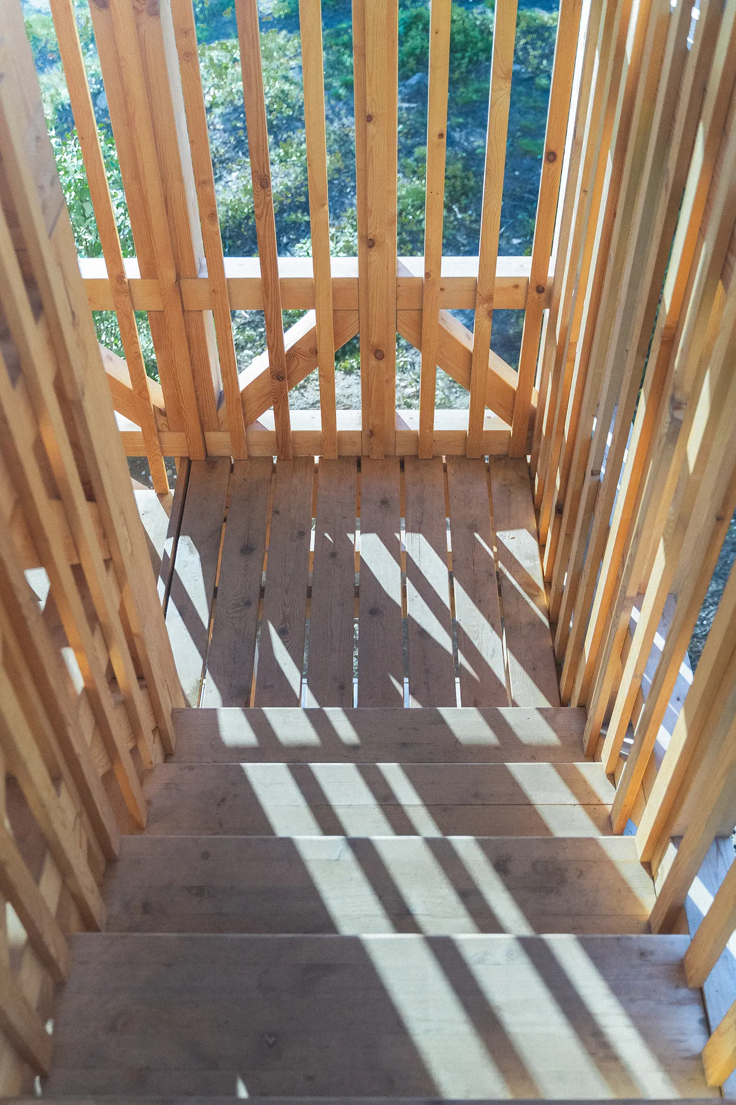 Kola Bay Lighthouse Viewpoint, interior stairwell view looking down through timber slats and shadow patterns