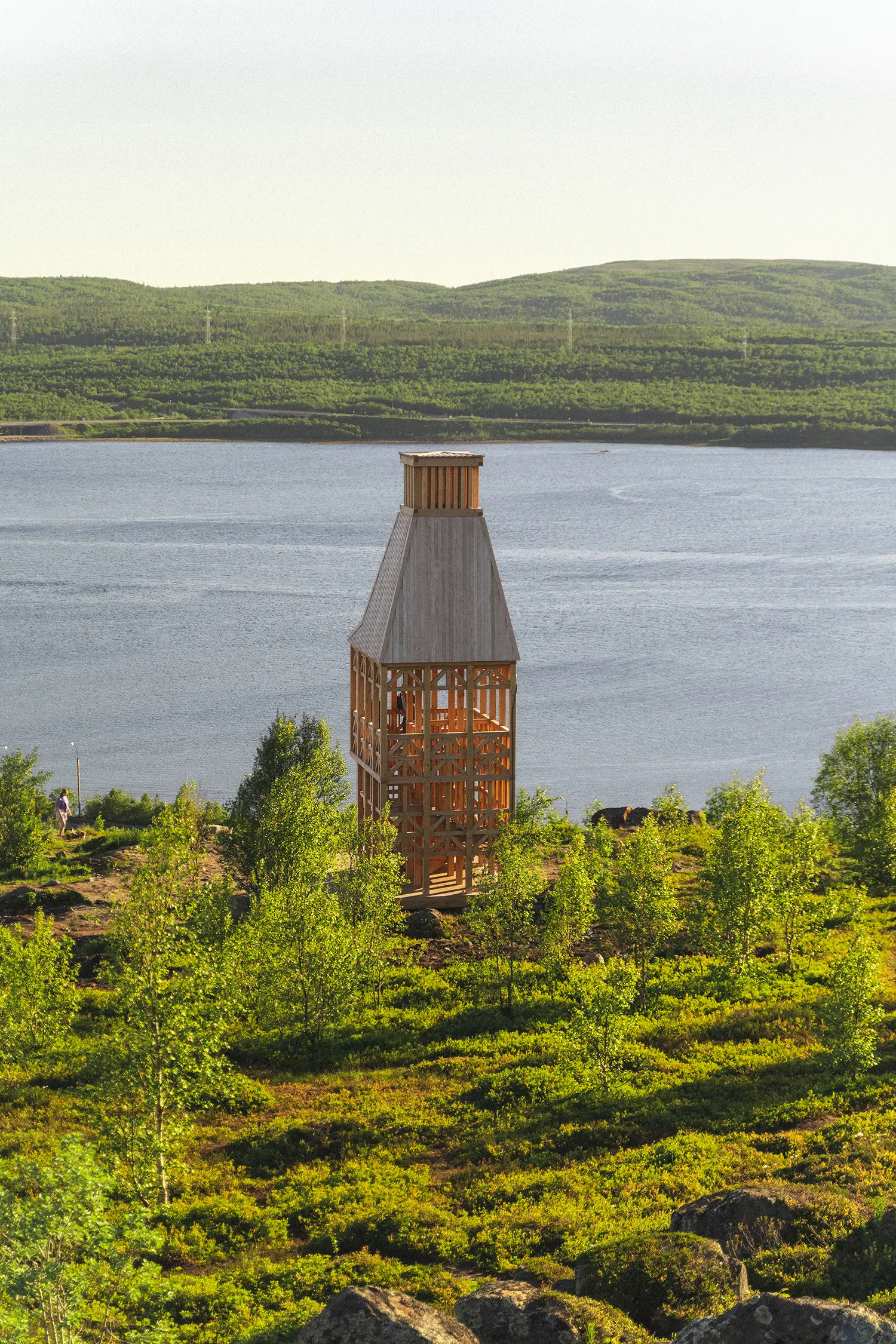 Kola Bay Lighthouse Viewpoint, tower seen from elevated hillside path with bay and hills behind
