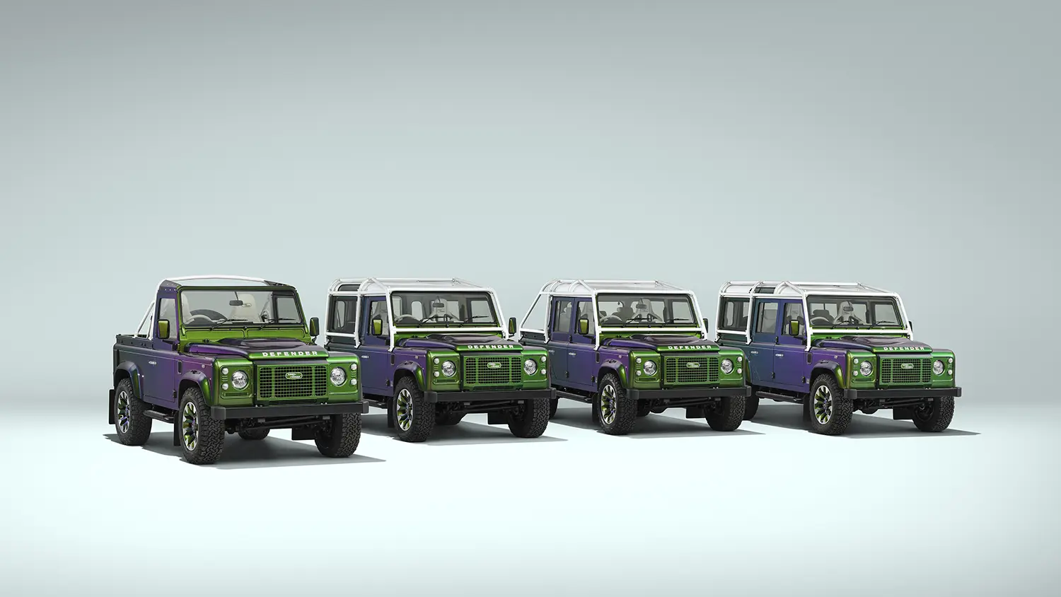 Four Land Rover Classic Defender V8 commissions in Spectral Green paint, front three-quarter lineup, 90 and 110 bodystyles