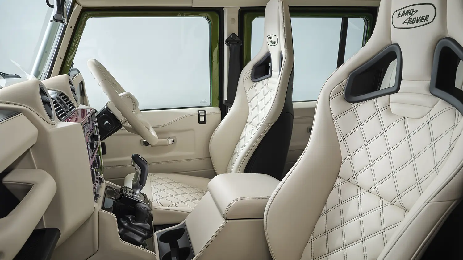 Land Rover Classic Defender V8 interior, quilted Vanilla leather seats with Land Rover branding, rear cabin view