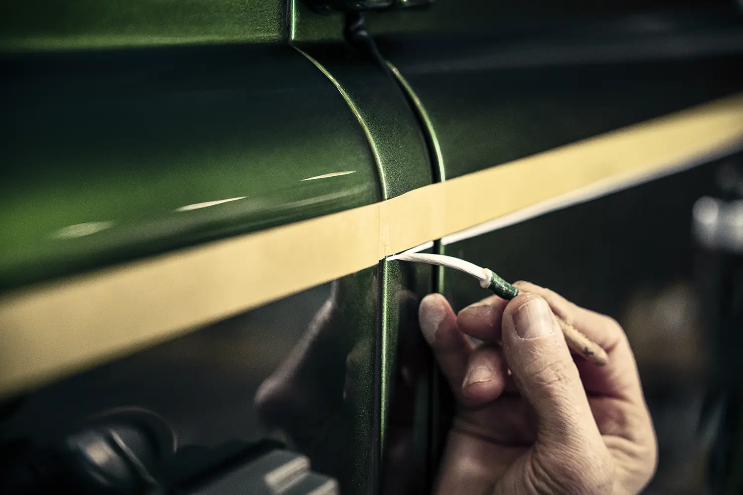 Land Rover Classic Defender V8 hand-painted white coachline applied over Spectral Green bodywork by a craftsman