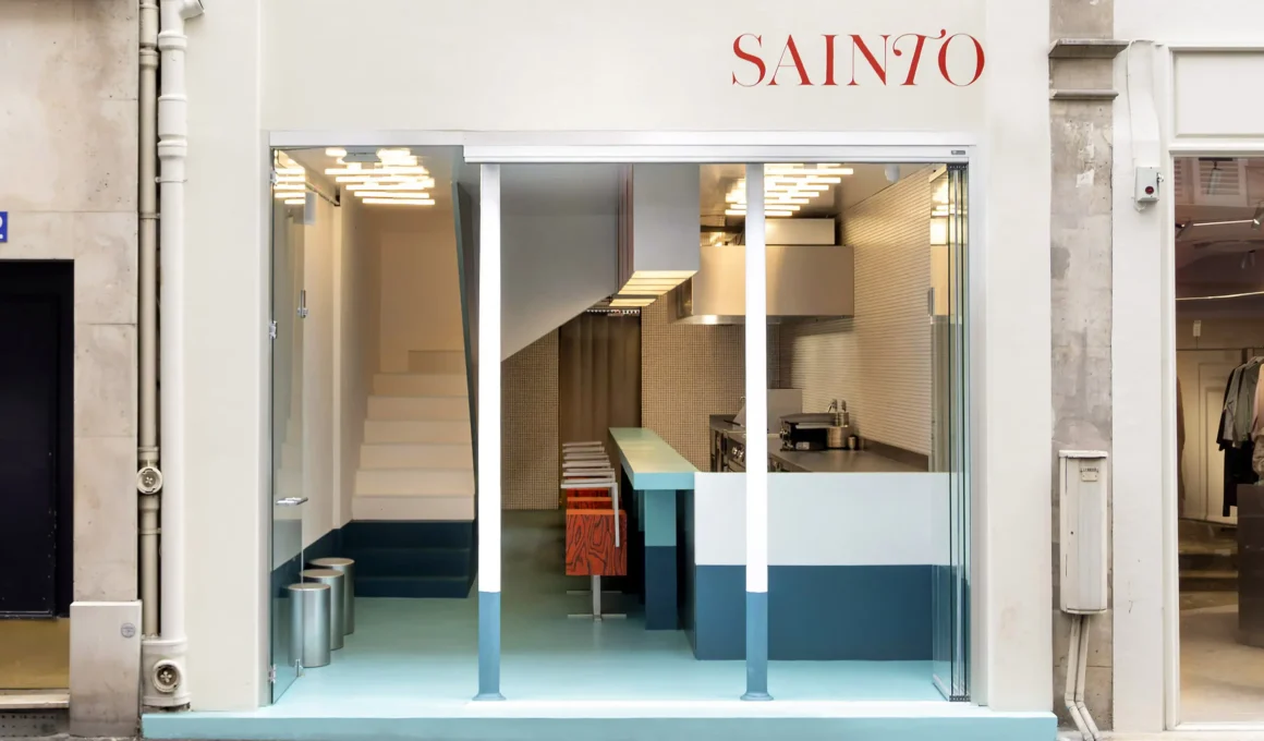 Sainto restaurant by Mur Mur, Paris — storefront view with teal-to-light floor gradient, staircase, and kitchen counter