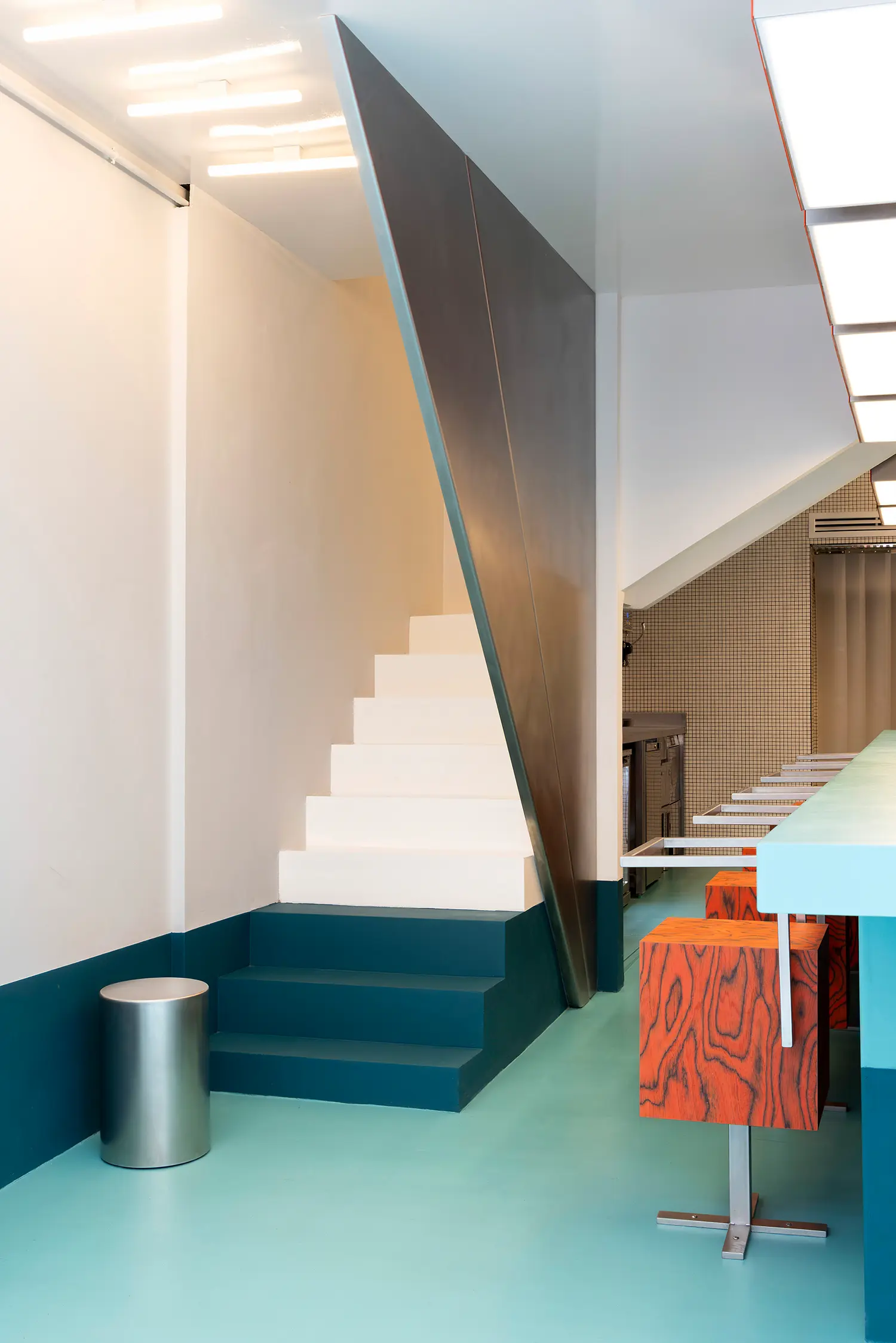 Sainto by Mur Mur, staircase with angled stainless steel railing running opposite the direction of the steps