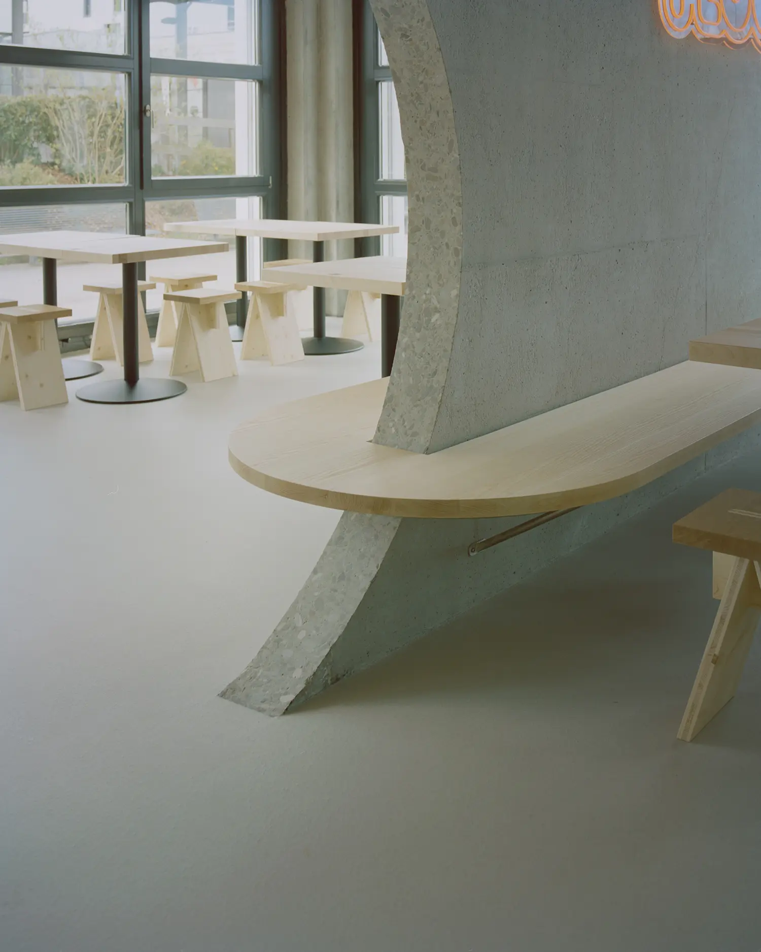 Eleventhfloor Restaurant by Noue Studio, detail of curved concrete bench with terrazzo edge and wood seat