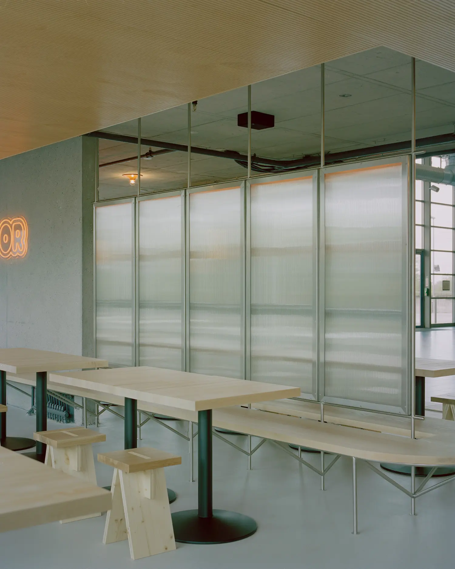 Eleventhfloor Restaurant by Noue Studio, polycarbonate partition wall with wood benches and neon signage