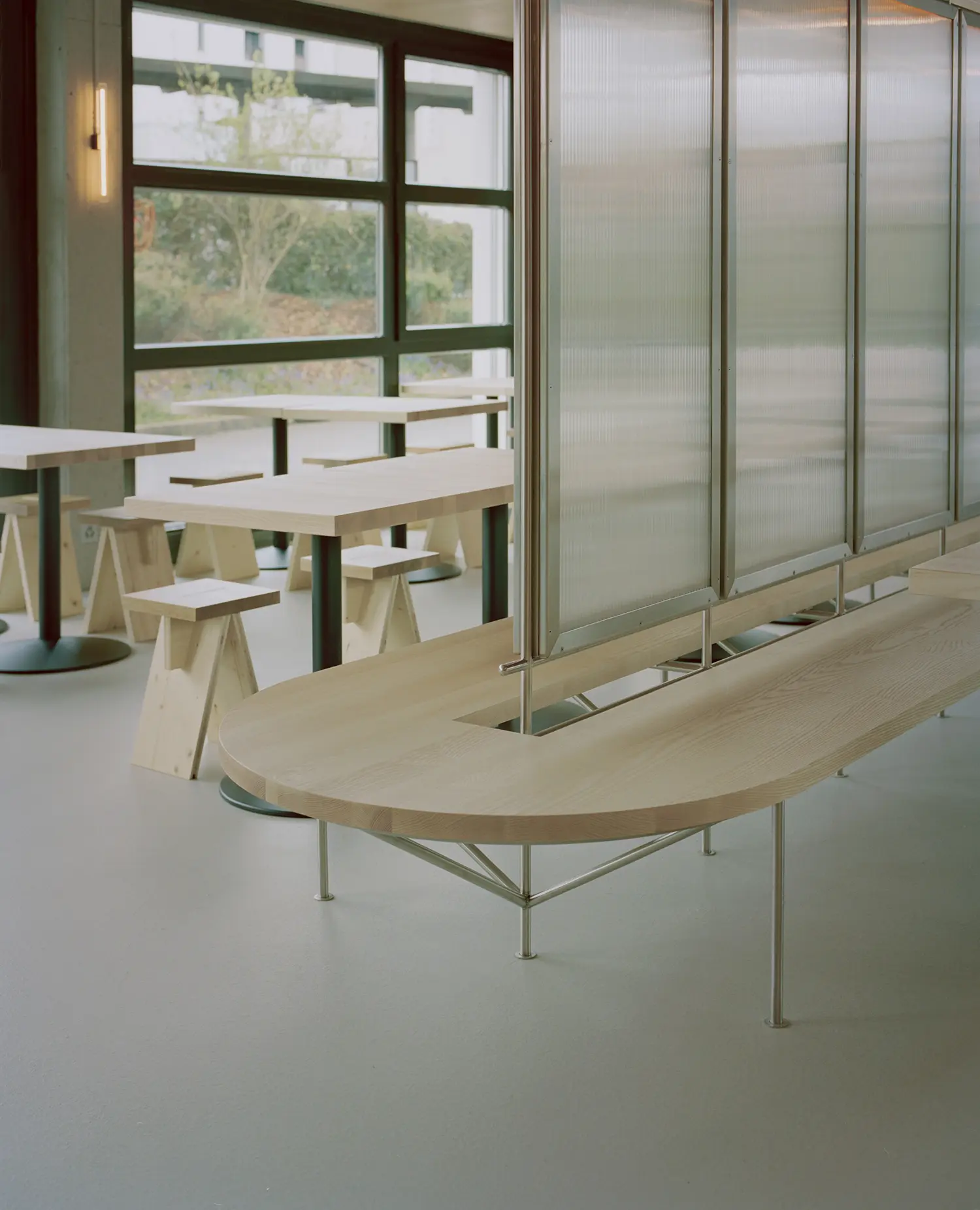Eleventhfloor Restaurant by Noue Studio, detail of wood bench meeting suspended polycarbonate divider