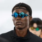 Model wearing Oakley wrapped-lens prototype eyewear in blue mirrored colorway backstage at Paris Fashion Week