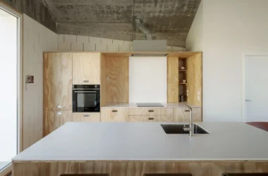 Cecebre House by Sinaldaba, Galicia, kitchen fully clad in pine plywood cabinetry, integrated oven, exposed concrete ceiling