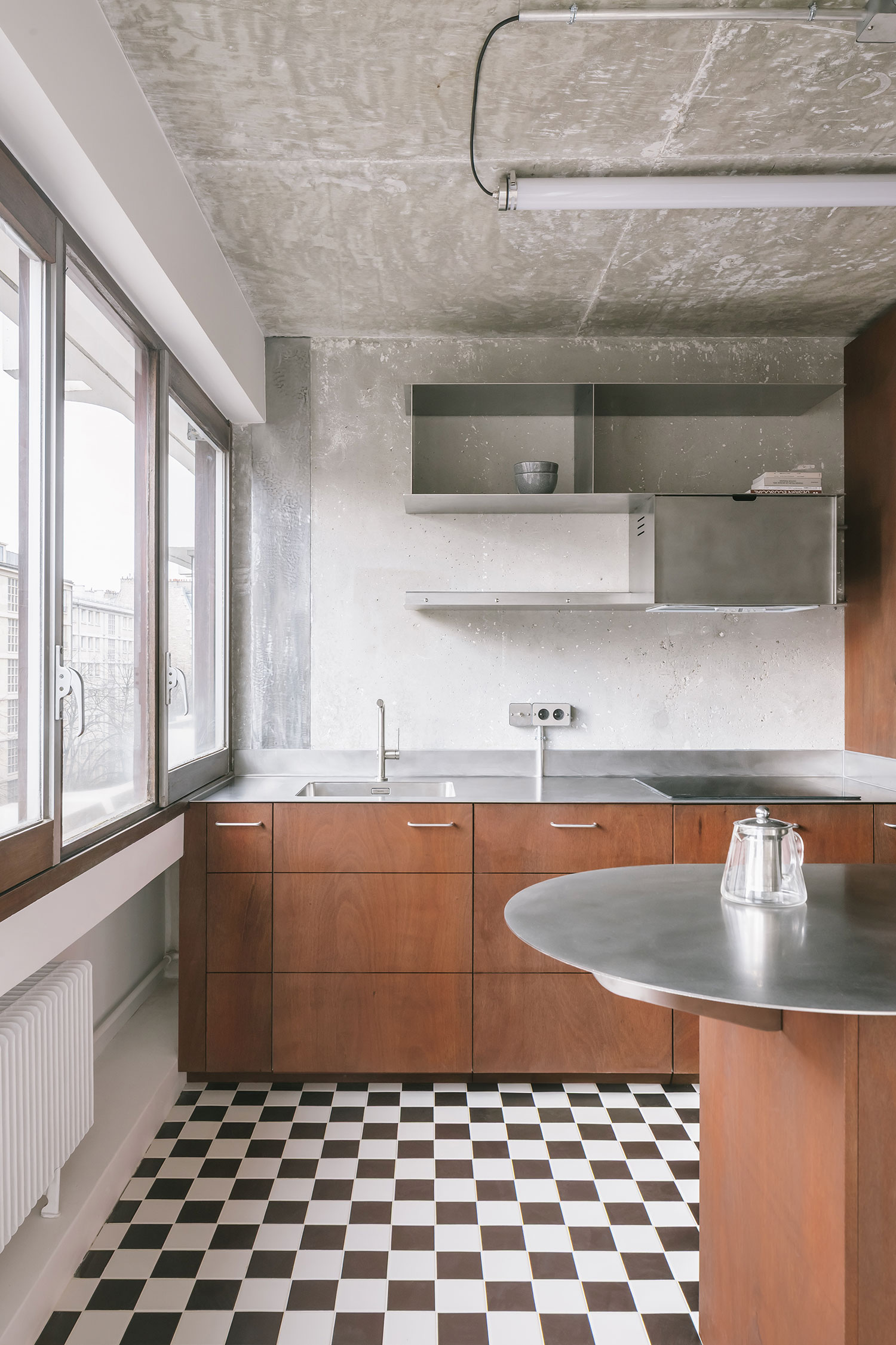 Apara Convention kitchen, Paris, okoumé plywood cabinetry, stainless steel counter, exposed concrete ceiling, checkerboard floor