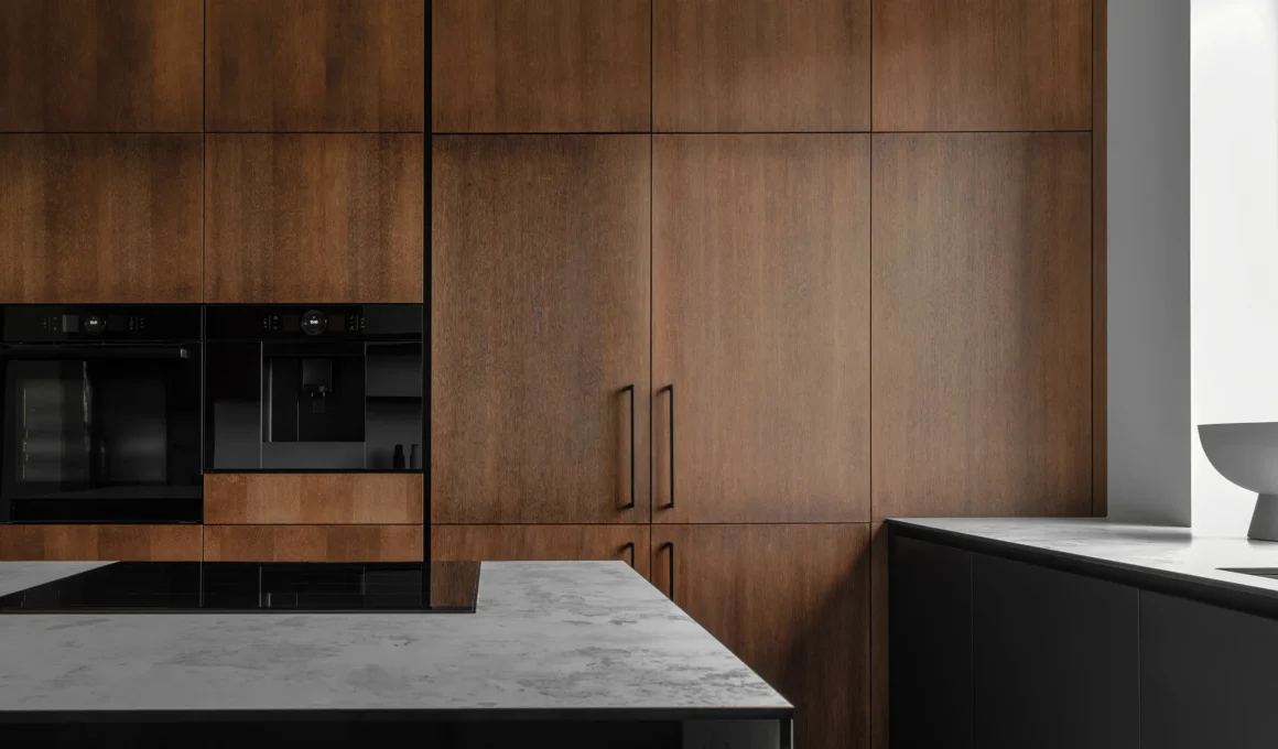 High-spec kitchen with walnut cabinetry, built-in oven, coffee machine, and stone island showing integrated appliance planning