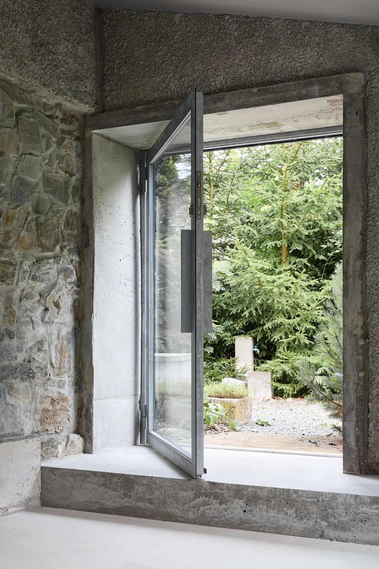 Panoší Újezd Summer House by Lenka Milerová: open steel-profile window without thermal bridge, framed by concrete reveal and original stone wall