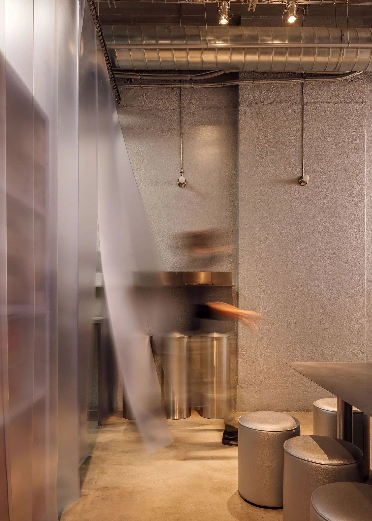 Motion blur of kitchen staff working at Street Smash Burgers by XXXI.studio, showing steel bins and industrial ceiling ductwork