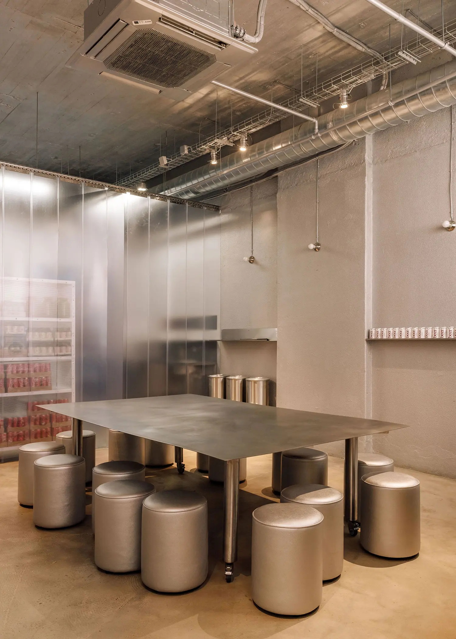 Communal steel dining table and beverage storage wall at Street Smash Burgers by XXXI.studio, Almada