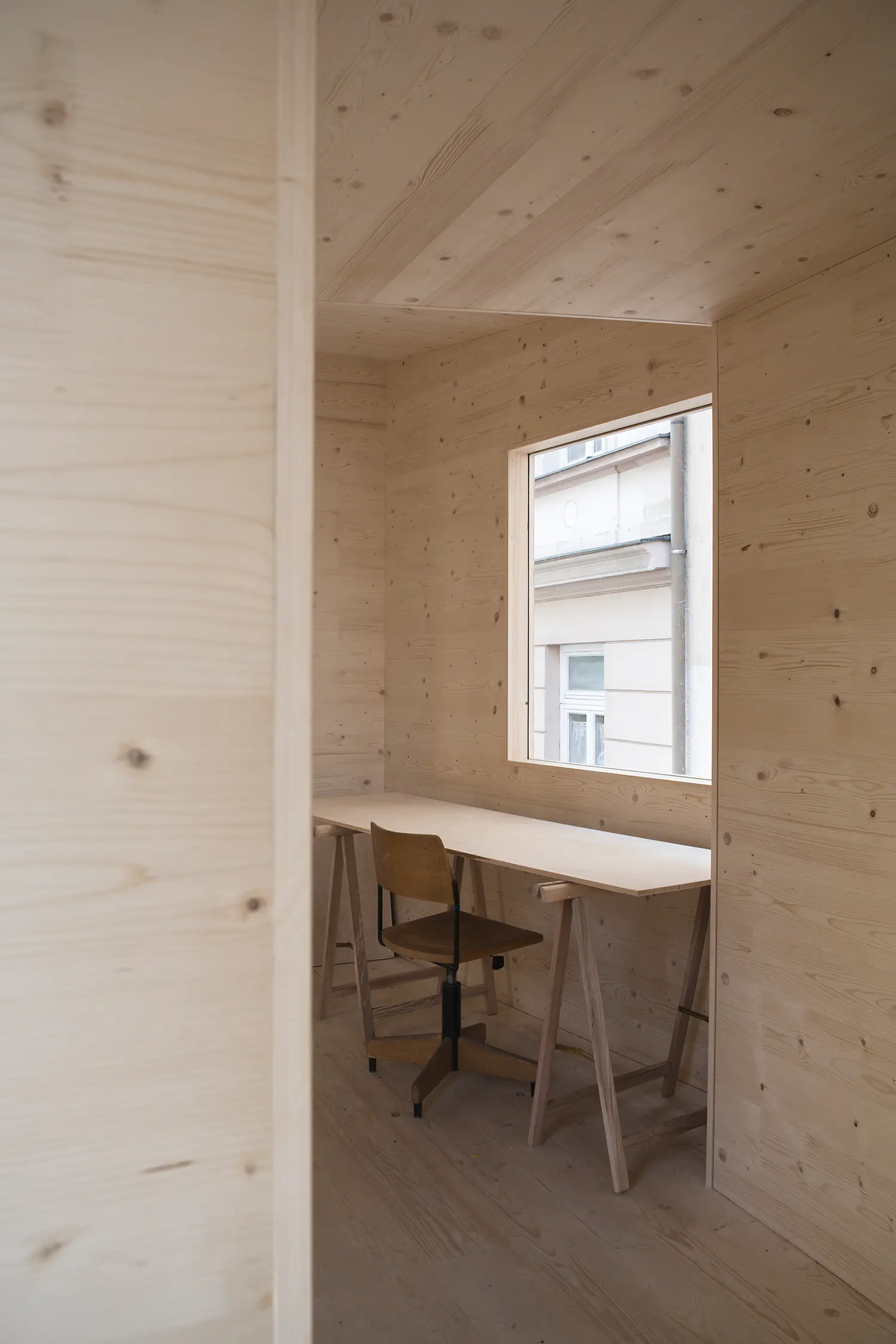ZuHaus by Clemens Hoyer, interior timber room with a desk and chair positioned beneath a window