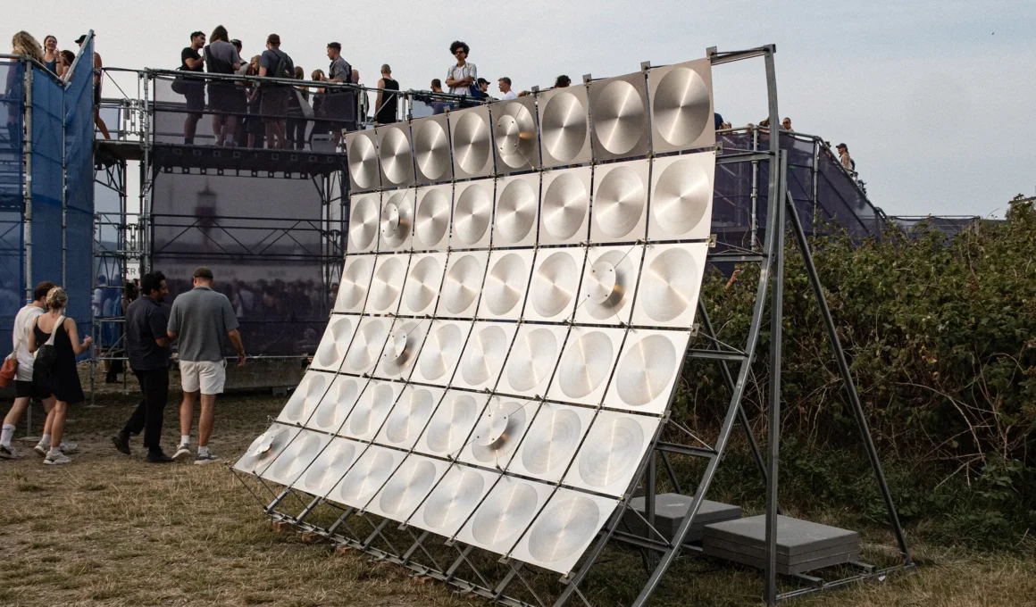 Speaker by Frederik Gustav, curved wall of circular-brushed aluminum panels at O Days Festival, Copenhagen