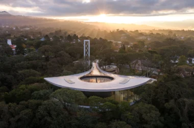 Aerial view of the Lola Mora Cultural Center by Pelli Clarke & Partners, its curving roof set in Yunga forest above San Salvador de Jujuy | Photo Jason O'Rear