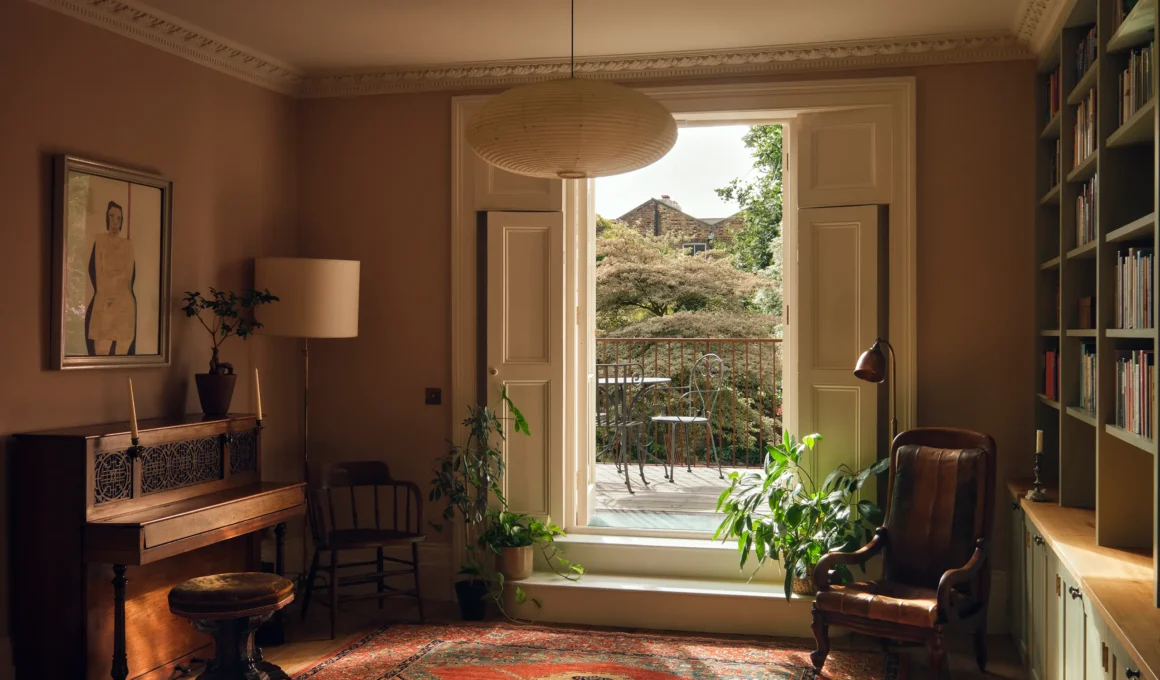 Upper-floor room at Mosley Thorold's De Beauvoir Townhouse, London, with tall doors opening onto a rear balcony over the garden