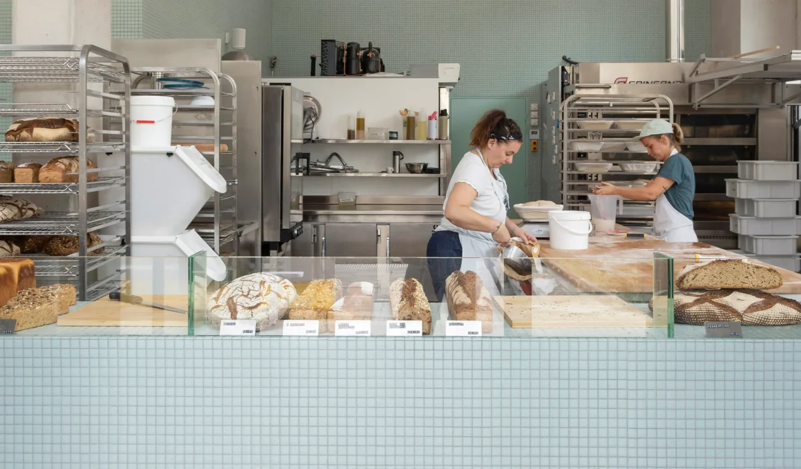 What the Bread bakery, Saint-Denis, by MUR.MUR Architectes: sourdough loaves in glass counter, open lab behind. Photo: Yvan Moreau